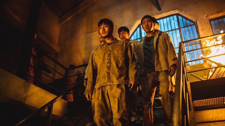 Money Heist Korea: JEA (L to R) Park Hae-soo as Berlin, Jang Yoon-ju as Nairobi, Yoo Ji-tae as Professor, Kim Ji-hun as Denver and Lee Won-jong as Moscow in episode # 1 of Money Heist Korea: JEA. Cr. Jung Jaegu/Netflix © 2021