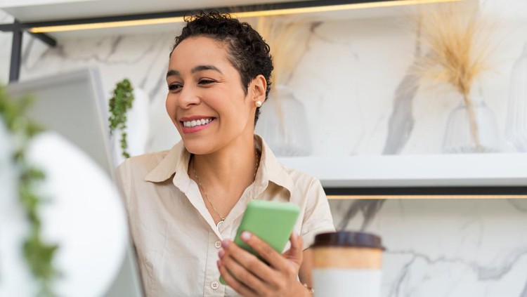 Wanita rambut pendek black woman working with mobile and laptop at home