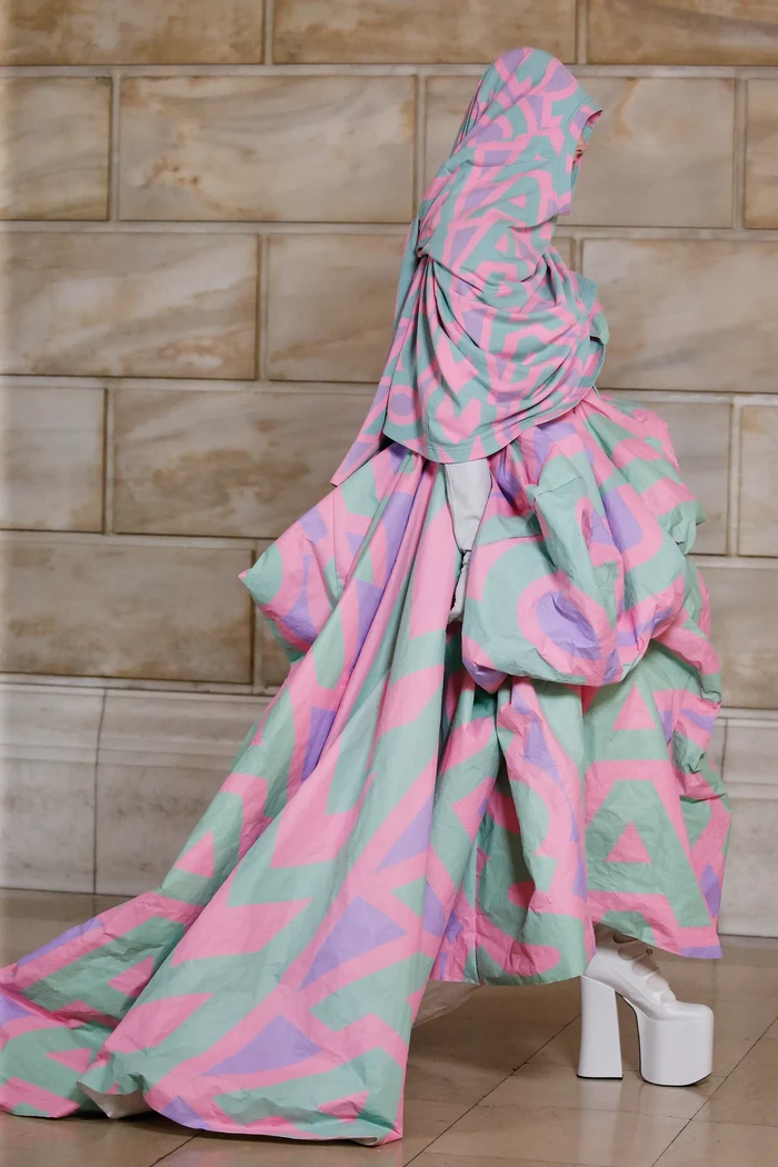 Kreasi logo dari musim lalu yang playful juga kini dipresentasikan secara dramatis jadi sebuah dress dan cape. Foto: Courtesy of Marc Jacobs