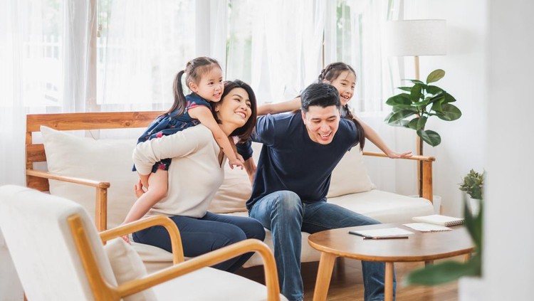 Happy Asian family playing together at sofa, home living room