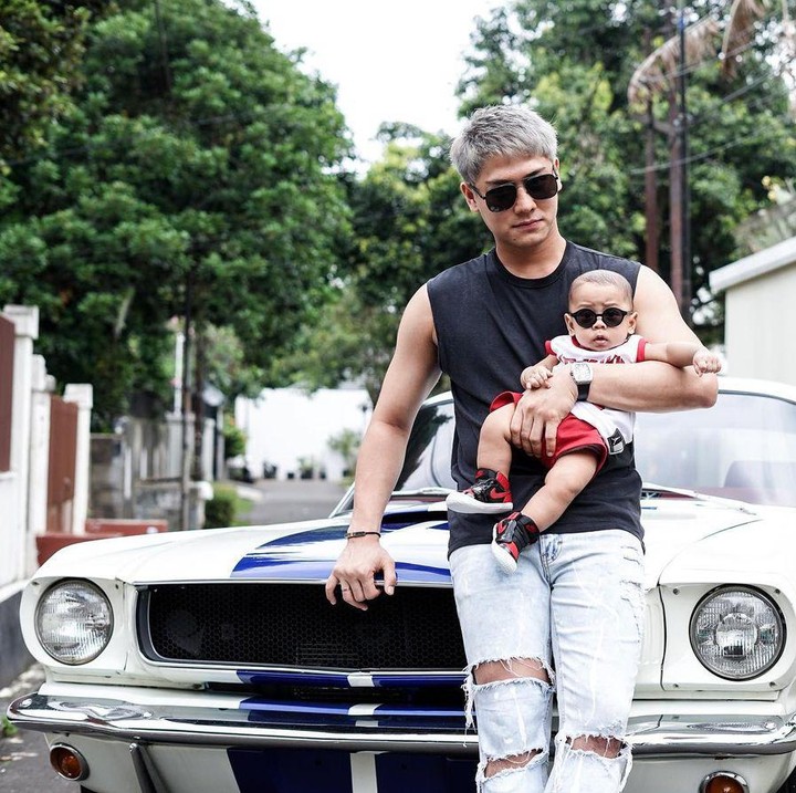 <p>Baby L memiliki wajah mirip Lesti dan Billar. Ia bergaya memakai kacamata hitam dipangkuan sang ayah. (Foto: Instagram @rizkybillar)</p>
