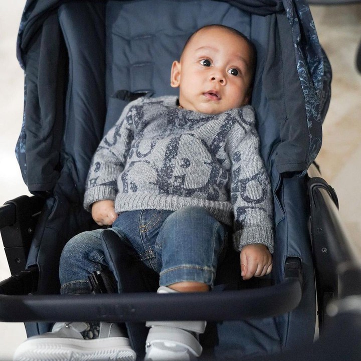 <p>Ini potretnya saat bersandar di atas <em>stroller</em>. Baby L tampil keren mengenakan <em>sweater</em> abu-abu dan celana jeans. (Foto: Instagram @rizkybillar)</p>