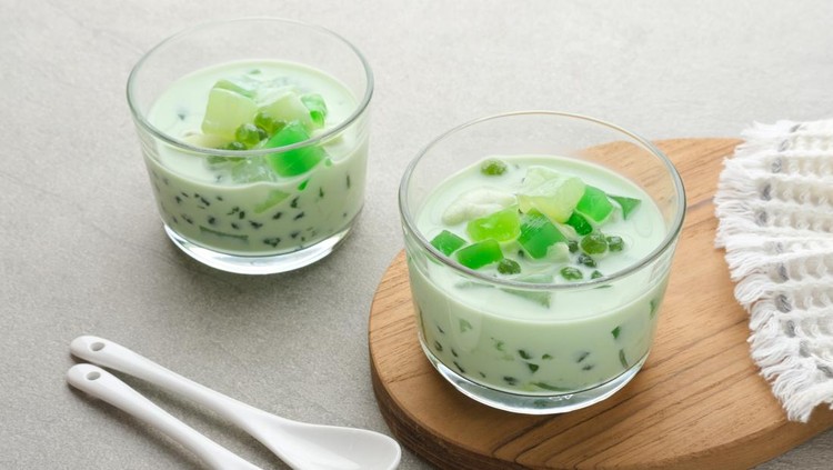 Ilustrasi Es Buko Pandan Buko Pandan, a dessert from Philippines, made from jelly, young coconut, evaporated milk, sweetened condensed milk, and ice. Served on glass. Selective focus.