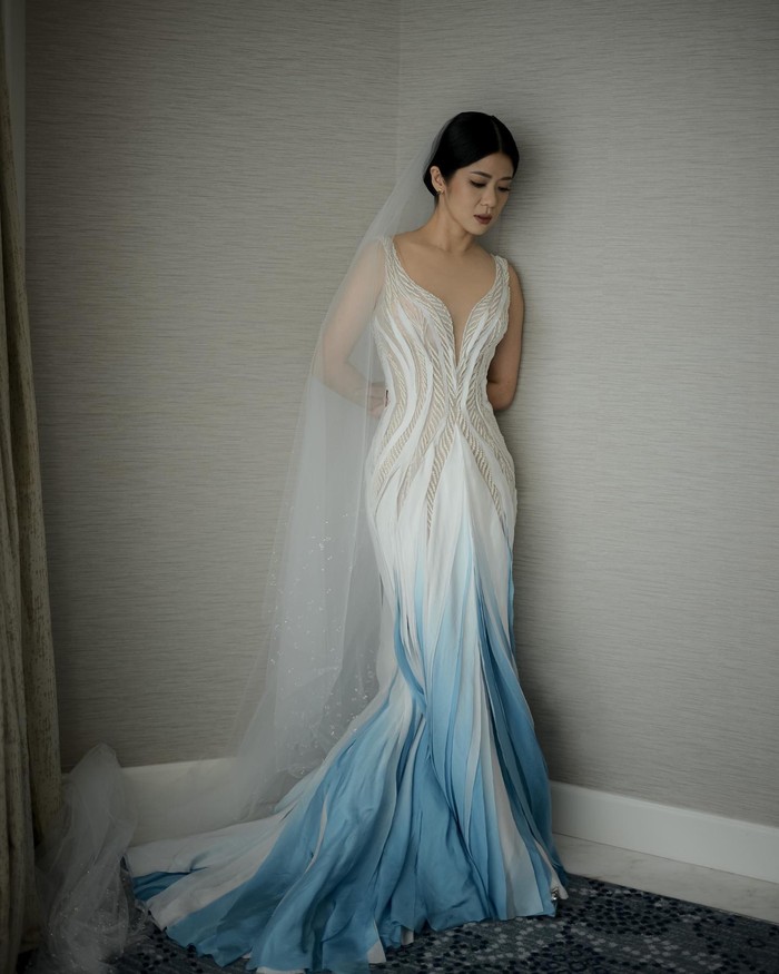 Detail ombre di bagian bawah membuat look gaun putih yang cantik jadi anti-mainstream. Sleeveless dress with plunging neckline ini dihiasi dengan manik-manik berbentuk daun. Tampilanmu pun terlihat lebih ramping dan memukau. (Foto: Instagram/Hian Tjen)
