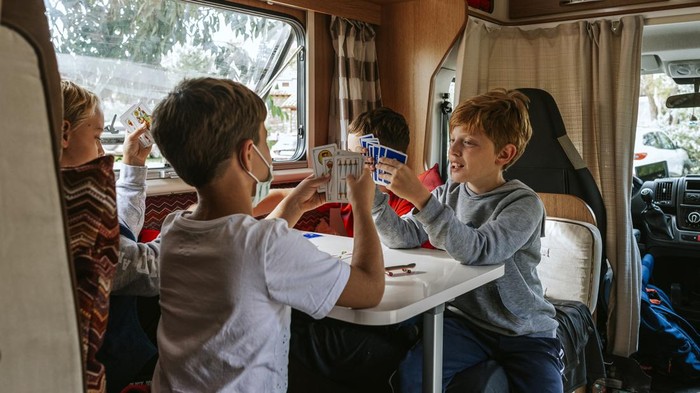 Children playing cards in a caravan
