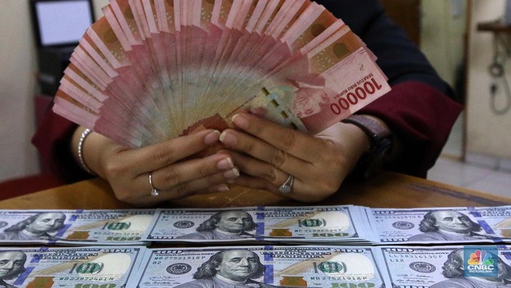 Pekerja pusat penukaran mata uang asing menghitung uang Dollar AS di gerai penukaran mata uang asing Dolarindo di Melawai, Jakarta, Senin (4/7/2022). (CNBC Indonesia/ Muhammad Sabki)