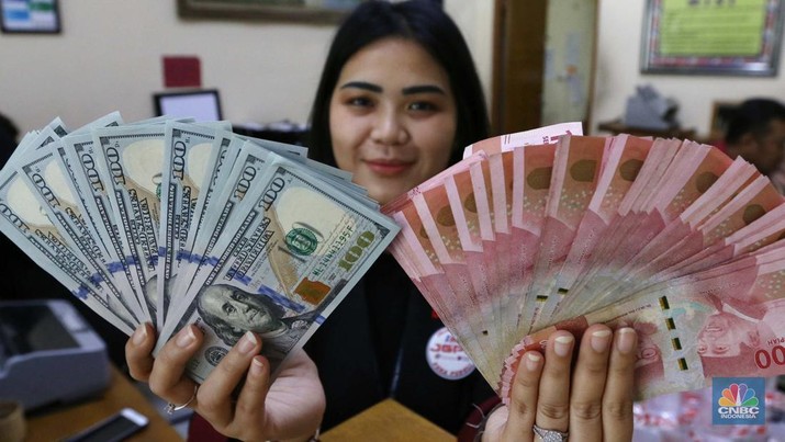 Pekerja pusat penukaran mata uang asing menghitung uang Dollar AS di gerai penukaran mata uang asing Dolarindo di Melawai, Jakarta, Senin (4/7/2022). (CNBC Indonesia/ Muhammad Sabki)