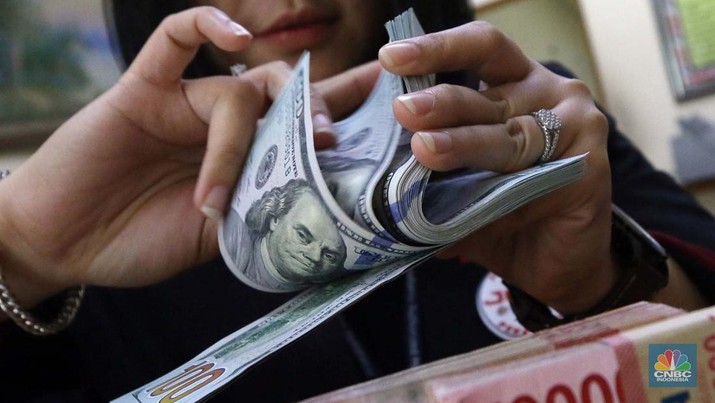 Pekerja pusat penukaran mata uang asing menghitung uang Dollar AS di gerai penukaran mata uang asing Dolarindo di Melawai, Jakarta, Senin (4/7/2022). (CNBC Indonesia/ Muhammad Sabki)