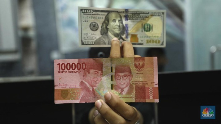 Pekerja memperlihatkan uang dolar di salah satu gerai money changer di Jakarta, Senin (4/7/2022).  (CNBC Indonesia/ Tri Susilo)