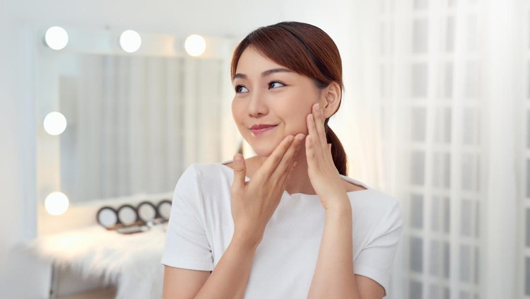 Attractive young Asian girl touching her face. Beauty & Skin care concept