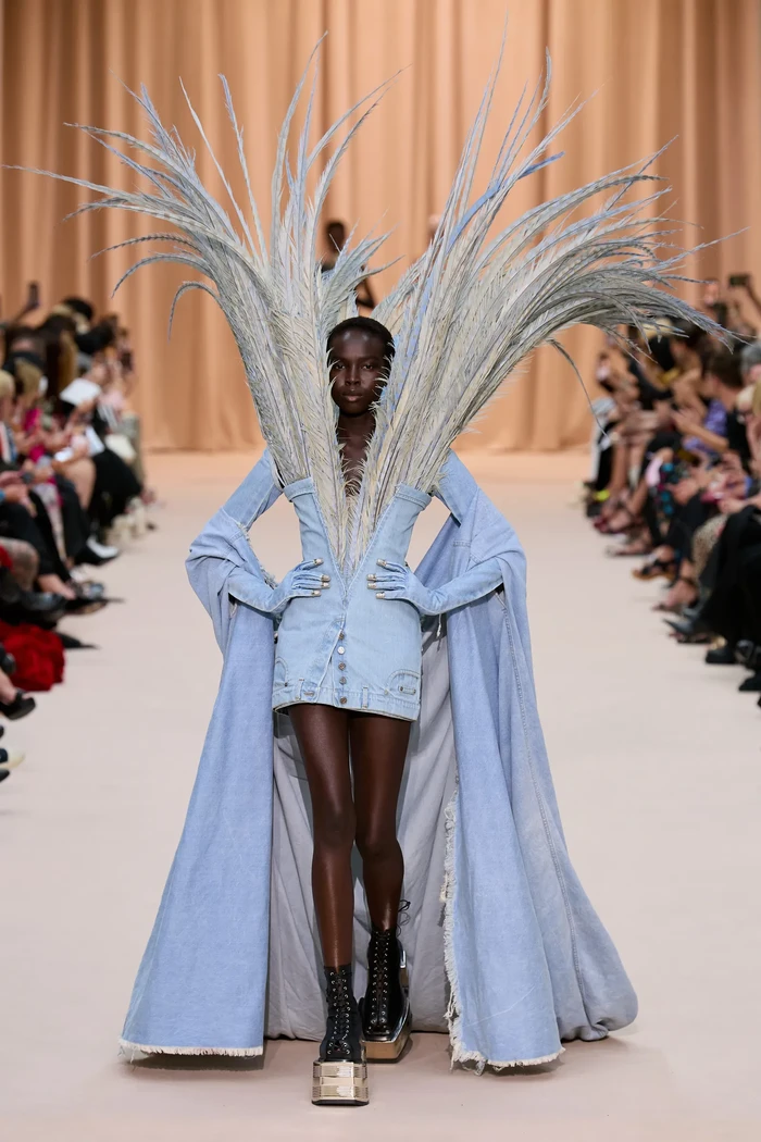Gaultier jadi salah satu desainer yang kerap menghadirkan denim di panggung couture. Rousteing mengemasnya secara dramatis lewat kreasi gaun dengan detail kerah tinggi feathers. Foto: Isidore Montag / Gorunway.com