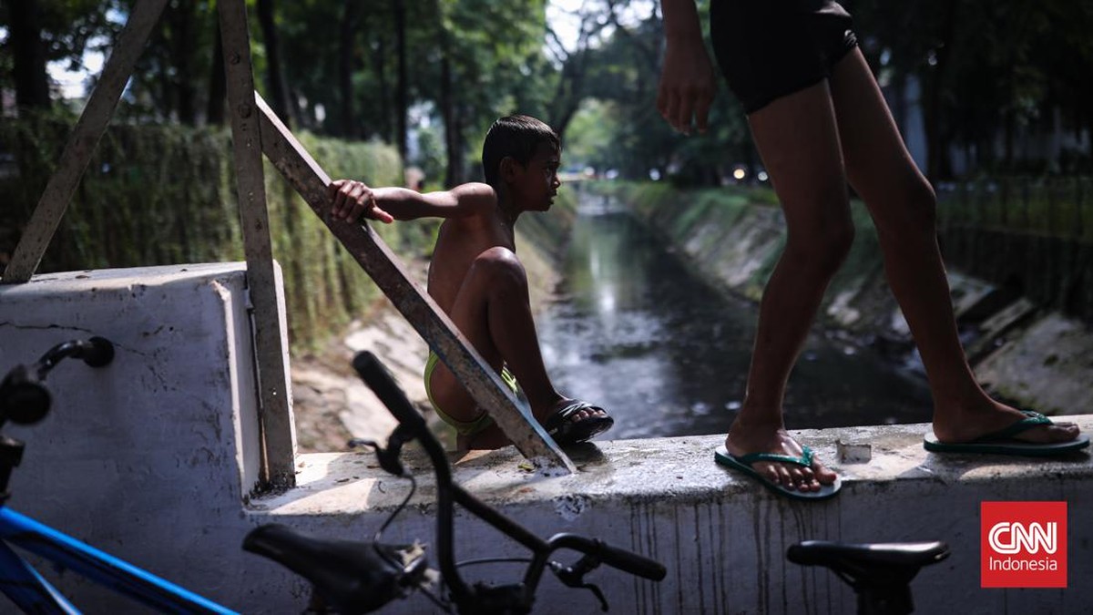 FOTO: Riang Bocah Mengisi Waktu Libur 'Nyebur' ke Kali