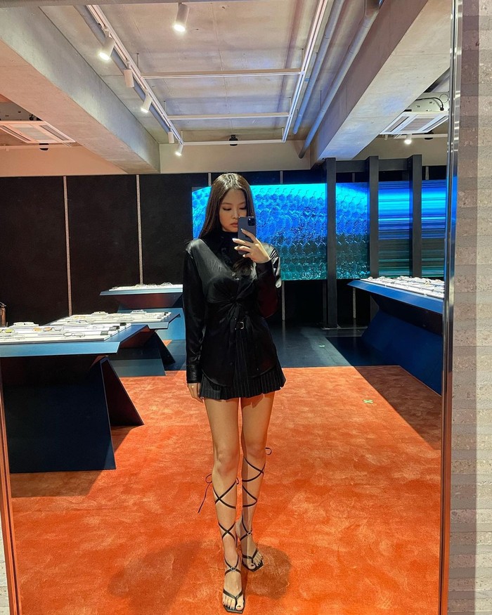 Nggak kalah keren dari outfit sebelumnya, kali ini cocok dipilih buat kamu yang suka tampil classy. Kemeja hitam dengan mini skirt warna senada, bikin kamu terlihat elegan. (Foto: Instagram/jennierubyjane).