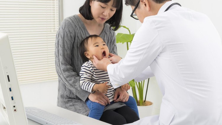 1127921908 Pediatrician doctor examining a little asian boy by stethoscope