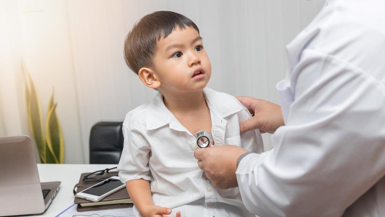 Pediatrician doctor examining a little asian boy by stethoscope