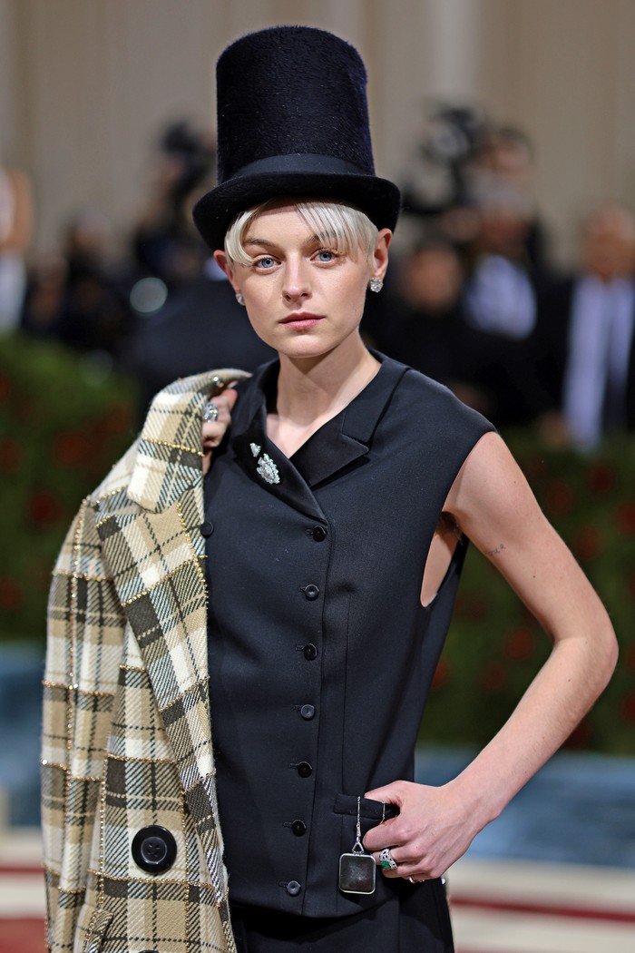 Jadi bintang iklan Miu Miu, tak heran bila ia sering memakai kreasi label ini. Contoh lain adalah saat hadir di Met Gala 2022. Saat yang lain heboh pakai gaun, Emma berani beda mengenakan kombinasi jaket plaid oversized bersama rompi dan celana pendek serta topi tinggi. Foto: Getty Images for The Met Museum//Dimitrios Kambouris