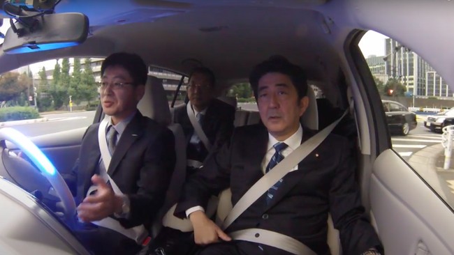 Shinzo Abe menumpangi Nissan Leaf dan mobil otonom yang dibuat oleh Honda dan Toyota di National Diet Front Garden.