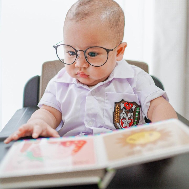 <p>Kali ini Rayyanza didandani mengenakan seragam sekolah. Ia memakai atribut anak SD lengkap dengan kacamatanya. (Foto: Instagram @raffinagita1717)</p>