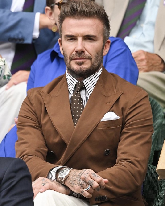 David Beckham duduk dibangku Royal Box mengenakan outfit Ralph Lauren berupa jas coklat lengkap dengan pocket square, dasi polkadot yang berpadu kemeja bergaris. Foto: instagram.com/ralphlauren
