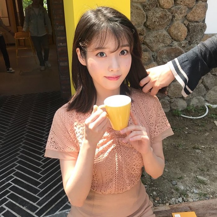 Suka tampil simpel tapi tetap modis? Coba outfit dari IU ini, yuk! Kombinasikan atasan blouse lengan pendek warna peach berbahan brokat dengan rok polos cokelat muda. (Foto: Instagram/dlwlrma).