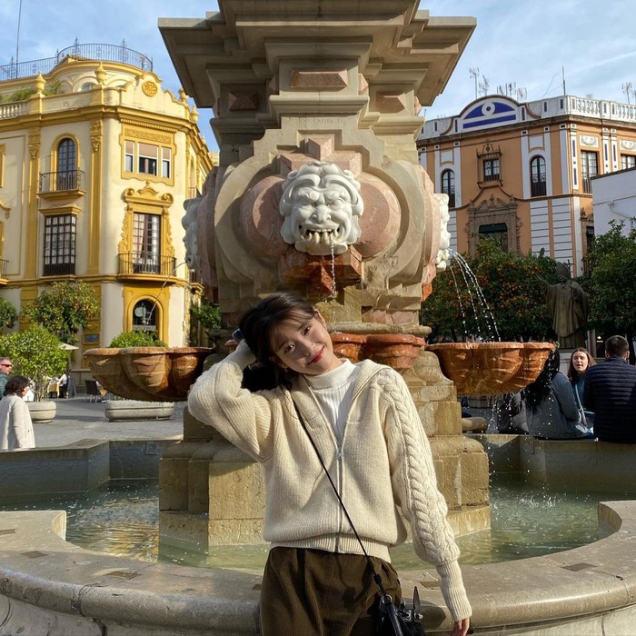 Nggak kalah stylish dari outfit sebelumnya, tampil jadi 'cewek bumi' ala IU kali ini juga bisa kamu tiru. Cukup mix and match cable knit kardigan warna krem dengan rok panjang coklat. (Foto: Instagram/dlwlrma).