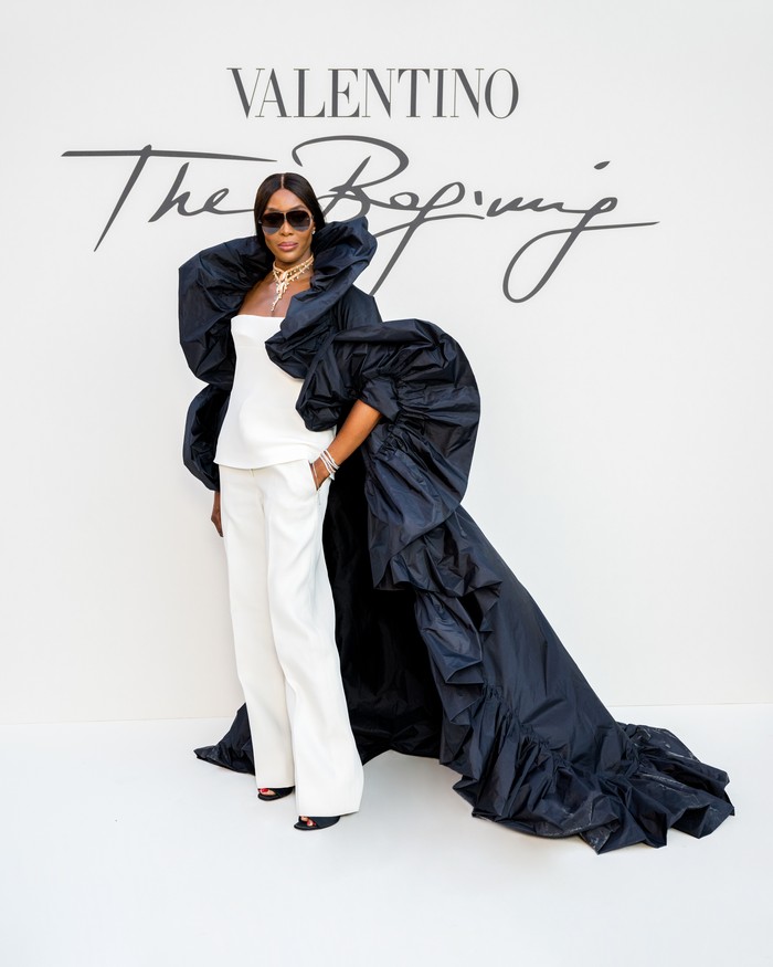 Supermodel Naomi Campbell memadukan bustier dan celana putih bersama coat panjang yang dramatis. Foto: ALFONSO CATALANO