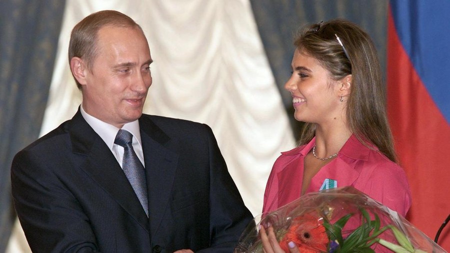Russian President Vladimir Putin (L) hands flowers to Alina Kabayeva, Russian rhytmic gymnastics star and Olympic prize winner, after awarding her with an Order of Friendship during annual award ceremony in the Kremlin 08 June 2001.   AFP PHOTO     EPA POOL/SERGEI CHIRIKOV        (Photo credit should read SERGEI CHIRIKOV/AFP via Getty Images)