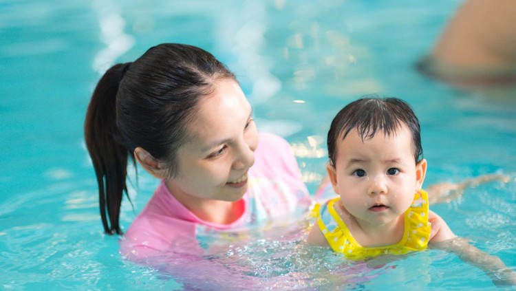 Asian Father take Cute little Asian 18 months / 1 year old toddler baby boy child to swimming class in Thailand, Happy infant enjoying his first swim in pool with his dad, Selective focus