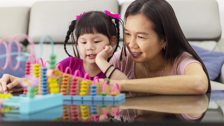 Ilustrasi Mengenal Minat dan Bakat Anak little girl learning mathematics using abacus at home, mother teaching beside patiently