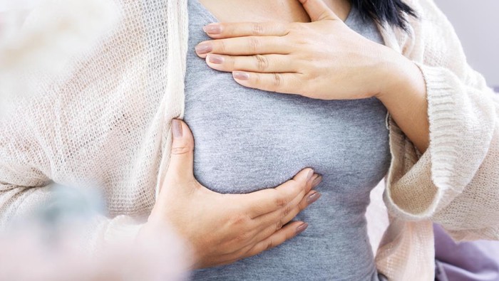 closeup woman hands self breast examination hand checking her breast cancer sign