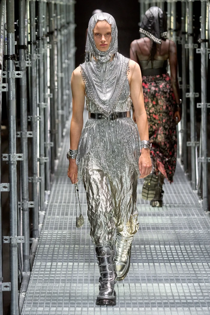 Selain Babushka Scarf, hadir versi headscarf lainnya dalam gaya ala era Medieval. Dossena menghadirkannya bersama chainmail dress yang jadi salah satu signature items dari label Paco Rabanne. Foto: Daniele Oberrauch / Gorunway.com