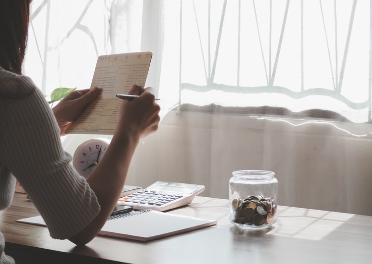 Women hands holding saving account passbook. financial report passbook saving money finance and business rich concept. financial problems, unemployment due to pandemic covid-19.