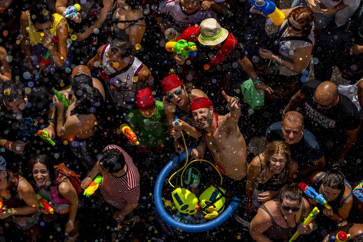 Warga Spanyol Lawan Cuaca Panas dengan Perang Air, Seru Banget People throw water at each other during the annual water fight in the streets of the Vallecas neighborhood of Madrid, Spain, Sunday, July 17, 2022. (AP Photo/Manu Fernandez)