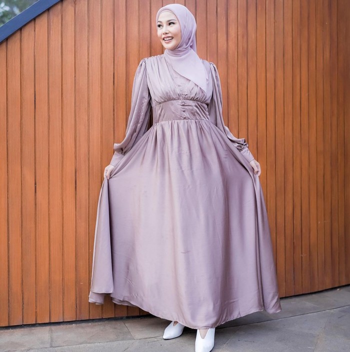 Gaun dengan kesan flowy makin membuatmu percaya diri. Desain gaun dan warnanya sudah manis, jadi tinggal padukan saja dengan kerudung berwarna senada. (Instagram.com/daraarfah)