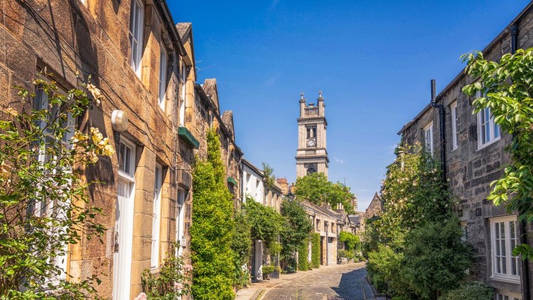 Ilustrasi Kota Paling Indah di Dunia Warm sunny July weather in Edinburgh, with flowers growing outside the mews houses on Circus Lane in Stockbridge, Edinburgh.