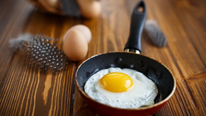 fried eggs in a frying pan on a table with eggs guinea fowl