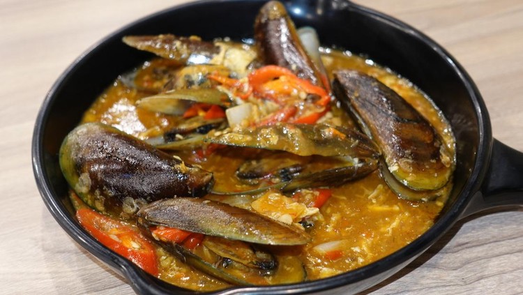 Ilustrasi Resep Masakan Rumahan Hemat Gas Green scallops in Padang sauce on a black baking sheet