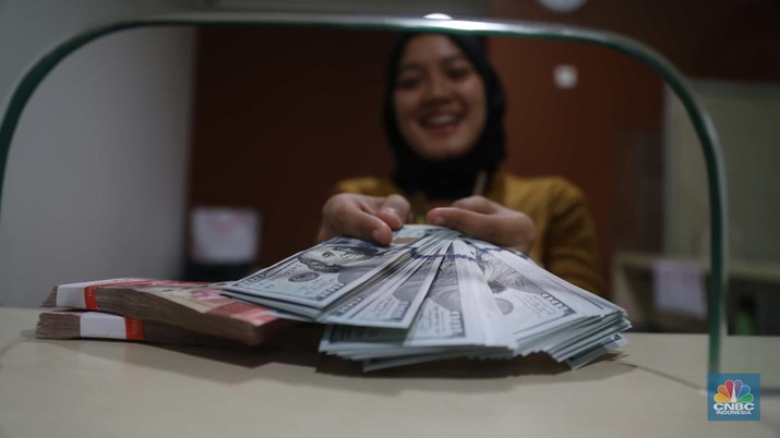 Petugas menghitung uang di tempat penukaran uang Luxury Valuta Perkasa, Blok M, Jakarta, Kamis, 21/7. Rupiah tertekan pada perdagangan Kamis (21/7/2022) (CNBC Indonesia/Muhammad Sabki)