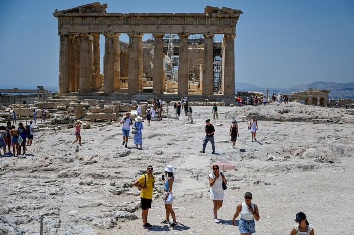 Turis di Acropolis, Athena kepanasan saat suhu udara mencapai 42 derajat celsius pada 24 Juli 2022. (Louisa Goulimaki/AFP via Getty Images) Turis di Acropolis, Athena kepanasan saat suhu udara mencapai 42 derajat celsius pada 24 Juli 2022. (Louisa Goulimaki/AFP via Getty Images)