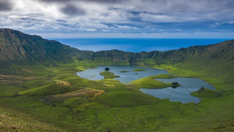 Ilustrasi Pulau Paling Kecil di Dunia Aerial view of volcanic crater (Caldeirao) with a beautiful lake on the top of Corvo island. Azores islands, Portugal.