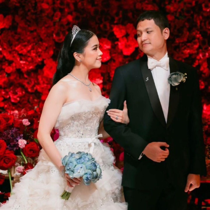 <p>Tak kalah menarik perhatian, Jessica tampil cantik dengan gaun warna putih dan mahkota di atas kepalanya. Ia pun memasuki ruangan sambil menggandeng sang suami. (Foto: Instagram: @liliana_tanoesodibjo)</p>