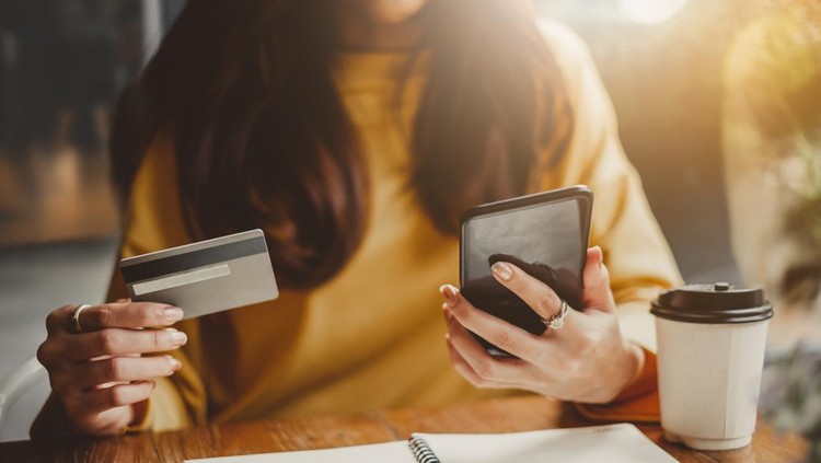 Ilustrasi Pinjaman Online Young beautiful asian woman using smart phone and credit card for shopping online in coffee shop cafe, vintage tone color