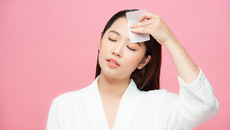 Ilustrasi Skincare Kulit Berminyak Woman using facial oil blotting paper. Photo of woman with perfect makeup on pink background. Beauty concept