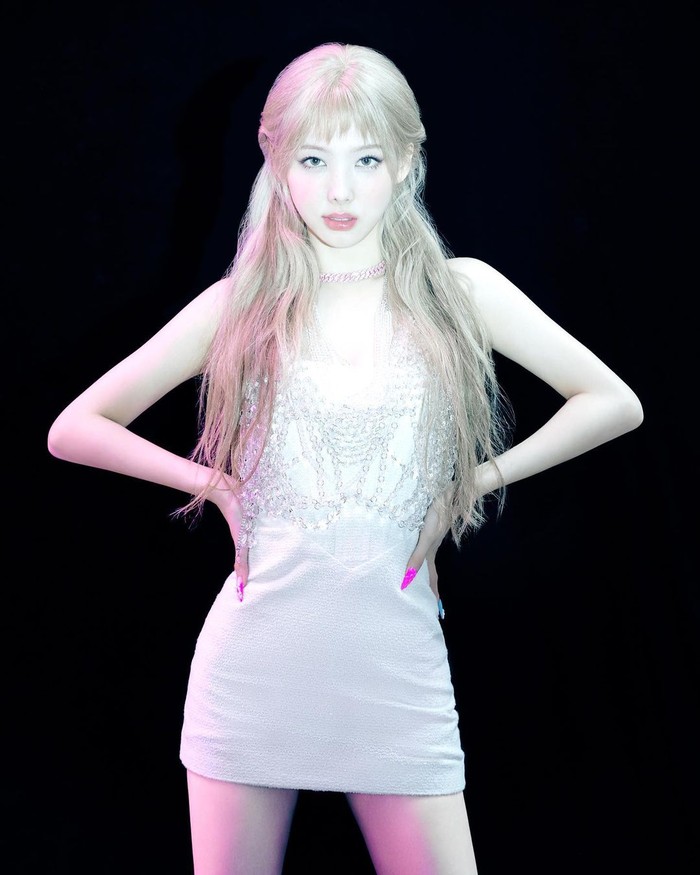 Berbeda dari biasanya, Nayeon juga memiliki poni cantik dengan riasan rambut rapi. Sangat cocok dengan mini dress putih dengan aksen manik kristal di bagian dada./ Foto: instagram.com/dazedkorea