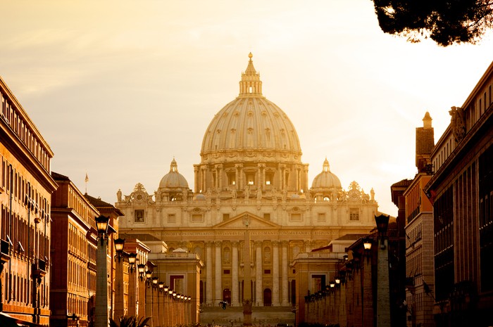 Vatican City, Vatican City State - August 21, 2008: St. Peter's Basilica at sunset from Via della Conciliazione. Vatican City State. Rome, Italy. Negara yang Hampir Tidak Pernah Perang Sejak Berdiri