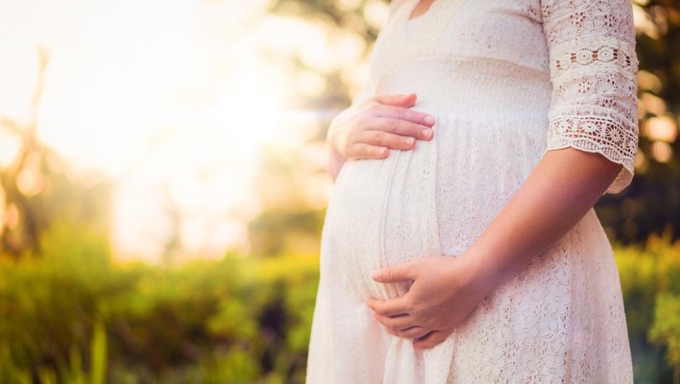 Ilustrasi Wanita Paling 'Subur' Pregnant woman feeling happy with new life at garden home while take care of her child. The young expecting mother holding baby in pregnant belly. Maternity prenatal care and woman pregnancy concept.