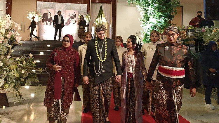 Gubernur DKI Jakarta Anies Baswedan menggandeng putrinya, Mutiara, usai resepsi pernikahan, Jumat (29/7/2022).