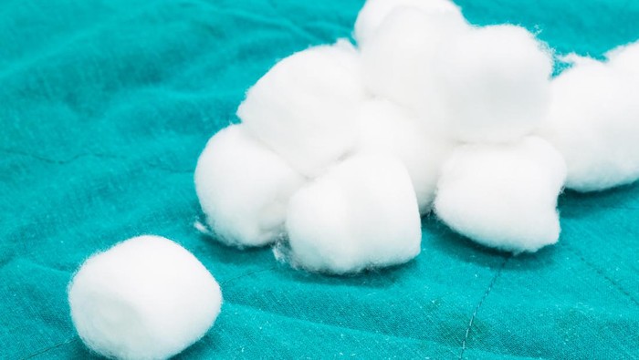 closeup of cotton wool on green fabric background.