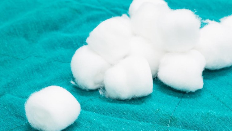 closeup of cotton wool on green fabric background.