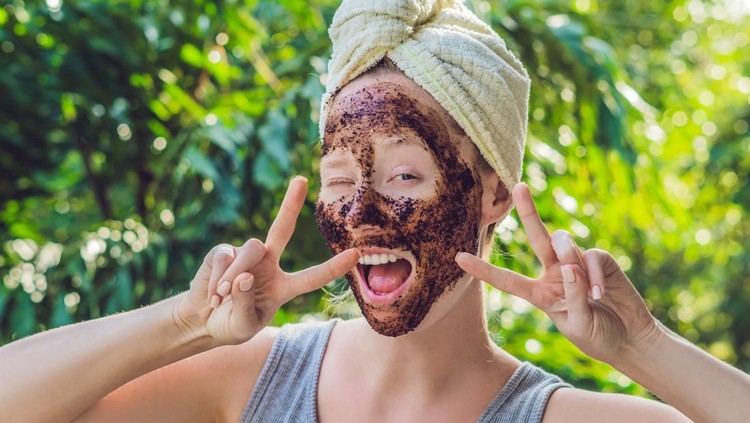 Ilustrasi Manfaat Masker Kopi Face Skin Scrub. Portrait Of Sexy Smiling Female Model Applying Natural Coffee Mask, Face Scrub On Facial Skin. Closeup Of Beautiful Happy Woman With Face Covered With Beauty Product. High Resolution.